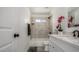 Updated bathroom with white vanity, marble-look tile, and bathtub at 1653 N 69Th Ave, Phoenix, AZ 85035