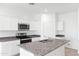 White kitchen with granite countertops and stainless steel appliances at 1714 W Spaulding Ave, Apache Junction, AZ 85120