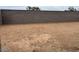 View of the empty backyard with a concrete block wall, ready for landscaping and personalization at 17457 W Eva St, Waddell, AZ 85355