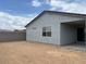 View of a backyard with a concrete block wall, showcasing a home's exterior and patio area at 17457 W Eva St, Waddell, AZ 85355