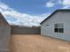 Side view of the backyard, featuring a block wall and home exterior with windows and covered patio at 17457 W Eva St, Waddell, AZ 85355