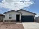 Charming single-story home featuring stone accents, a two-car garage, and desert landscaping at 17457 W Eva St, Waddell, AZ 85355