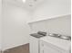 Convenient laundry room with modern washer and dryer units, with ample shelving space at 17457 W Eva St, Waddell, AZ 85355