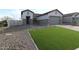 Charming single-story home featuring stone accents, a well-manicured lawn, and a two-car garage at 19315 W Luke Ave, Litchfield Park, AZ 85340