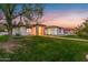 Single-story house with landscaped yard, walkway, and beautiful sunset at 21086 E Mewes Rd, Queen Creek, AZ 85142