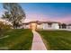 Attractive single-story house with stone accents and landscaped yard at dusk at 21086 E Mewes Rd, Queen Creek, AZ 85142