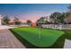 Landscaped backyard putting green with flag and pergola at 21086 E Mewes Rd, Queen Creek, AZ 85142