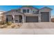 Two-story home with gray exterior, three-car garage, and landscaped front yard at 25509 N 140Th Dr, Surprise, AZ 85387