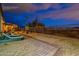 Serene backyard patio with seating area and mountain views at night at 26063 N 83Rd Dr, Peoria, AZ 85383