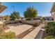 Landscaped front yard with walkway, mature trees and desert plants at 26458 W Yukon Dr, Buckeye, AZ 85396