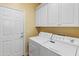 Bright laundry room with washer, dryer, and cabinets at 26458 W Yukon Dr, Buckeye, AZ 85396