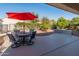 Relaxing patio with seating area and red umbrella at 26458 W Yukon Dr, Buckeye, AZ 85396