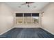 Spacious bedroom with dark carpet and ceiling fan at 30401 N 115Th Dr, Peoria, AZ 85383