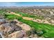 Aerial view of golf course with houses lining the edge of the green grass at 30626 N 45Th Pl, Cave Creek, AZ 85331