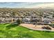 Expansive aerial view of a desert community, showcasing lush green fairways, sparkling pools, and mountain views at 30626 N 45Th Pl, Cave Creek, AZ 85331