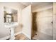 Bathroom with a pedestal sink and walk-in shower with tiled walls and flooring at 30626 N 45Th Pl, Cave Creek, AZ 85331