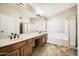 Bathroom featuring a large vanity with dual sinks and a separate tub and shower at 30626 N 45Th Pl, Cave Creek, AZ 85331