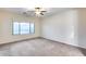 Carpeted bedroom with a large window and ceiling fan at 3167 E Battala Ct, Gilbert, AZ 85297