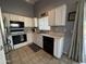 Well-lit kitchen featuring white cabinetry, stainless steel appliances, and tile flooring at 3560 W Tina Ln, Glendale, AZ 85310