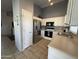 Functional kitchen with stainless steel appliances, white cabinetry, and tile flooring for easy maintenance at 3560 W Tina Ln, Glendale, AZ 85310