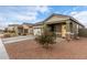 House exterior with a two-car garage and small tree at 36060 W Santa Clara Ave, Maricopa, AZ 85138