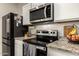 Modern kitchen with stainless steel stove and microwave at 36060 W Santa Clara Ave, Maricopa, AZ 85138