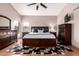 Spacious bedroom with dark wood furniture and ceiling fan at 3664 E Juanita Ave, Gilbert, AZ 85234