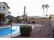 Backyard oasis with a sparkling pool, covered patio, and lush desert landscaping at 3664 E Juanita Ave, Gilbert, AZ 85234