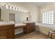 Elegant bathroom with double vanities, a chandelier, and a bathtub at 4644 W Soft Wind Dr, Glendale, AZ 85310