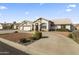 Curved driveway, three-car garage, desert landscaping, and a three-bedroom home at 4644 W Soft Wind Dr, Glendale, AZ 85310