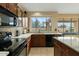 Modern kitchen with granite countertops, dark wood cabinets, and a large window at 517 N Cambridge St, Gilbert, AZ 85233