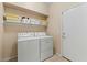 Convenient laundry room with washer, dryer, and shelving for storage at 517 N Cambridge St, Gilbert, AZ 85233