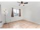 Bright bedroom with large window and ceiling fan at 5321 W Country Gables Dr, Glendale, AZ 85306