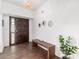 Bright entryway with wood-look tile floors, bench, and dark wood front door at 6030 E Crocus Dr, Scottsdale, AZ 85254