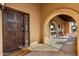 Ornate wooden front door with glass sidelights and a welcome mat at 6030 E Crocus Dr, Scottsdale, AZ 85254