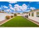 Artificial turf backyard, bordered by gravel and a white wall at 8602 E Plaza Ave, Scottsdale, AZ 85250