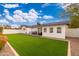 View of the home's back and a grassy backyard at 8602 E Plaza Ave, Scottsdale, AZ 85250