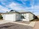 House exterior showcasing a white garage door and a gravel driveway at 8728 W Vale Dr, Phoenix, AZ 85037