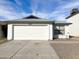 Front view of a house with a white garage door and a gravel driveway at 8728 W Vale Dr, Phoenix, AZ 85037