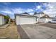 Front view of a single-story house with a white garage door and rock landscaping at 8728 W Vale Dr, Phoenix, AZ 85037