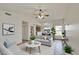 Bright living room with ceiling fan, open floor plan, stylish furniture, and view into kitchen/dining areas at 8728 W Vale Dr, Phoenix, AZ 85037