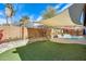 Inviting backyard featuring green lawn, mature landscaping and a refreshing pool beneath a shade sail at 8818 W Virginia Ave, Phoenix, AZ 85037