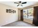 Cozy bedroom featuring carpeted flooring, a ceiling fan and a window view of the backyard pool at 8818 W Virginia Ave, Phoenix, AZ 85037