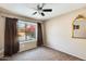 Bright bedroom with large window overlooking the pool and backyard, carpeted flooring and ceiling fan at 8818 W Virginia Ave, Phoenix, AZ 85037