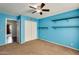 Well-lit bedroom with blue accent walls, carpeted flooring and a walk-in closet at 8818 W Virginia Ave, Phoenix, AZ 85037