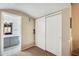 Hallway view of bathroom with large mirror vanity and sliding door closet at 8818 W Virginia Ave, Phoenix, AZ 85037