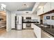 Modern kitchen with stainless steel appliances, white cabinets, and black countertops at 8818 W Virginia Ave, Phoenix, AZ 85037