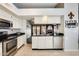 Open kitchen layout with white cabinetry, breakfast bar, and stainless steel appliances at 8818 W Virginia Ave, Phoenix, AZ 85037