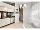 Bright kitchen area featuring black countertops, stainless steel dishwasher, and chandelier lighting at 8818 W Virginia Ave, Phoenix, AZ 85037