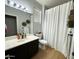 Well-lit bathroom with a vanity, decorative mirror, and a shower with a white curtain at 9024 W Alda Way, Peoria, AZ 85382